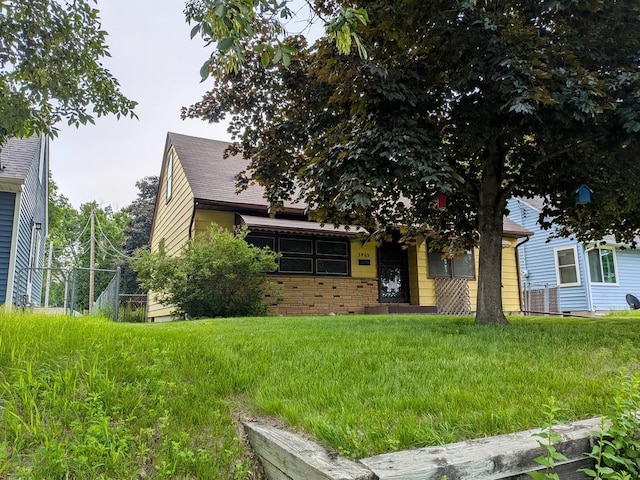 3465 5th St NE, Minneapolis, MN 55418 - obstructed view of property featuring brick siding and roof with shingles
