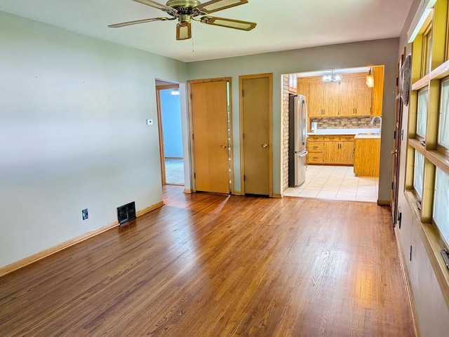 3465 5th St NE, Minneapolis, MN 55418 - empty room with ceiling fan and light wood-style flooring