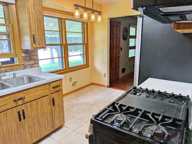 3465 5th St NE, Minneapolis, MN 55418 - kitchen featuring range with gas stovetop, light tile patterned floors, range hood, light countertops, and hanging light fixtures