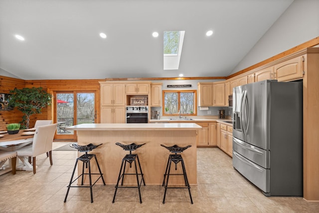 631 Pheasant Run, Winsted, MN 55395 - kitchen featuring appliances with stainless steel finishes, vaulted ceiling, light brown cabinets, a skylight, and light countertops