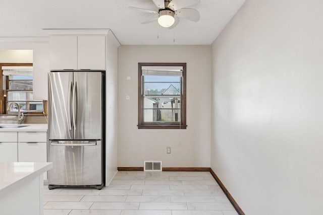 2514 5th St NE, Minneapolis, MN 55418 - kitchen with freestanding refrigerator, healthy amount of natural light, light countertops, and white cabinetry