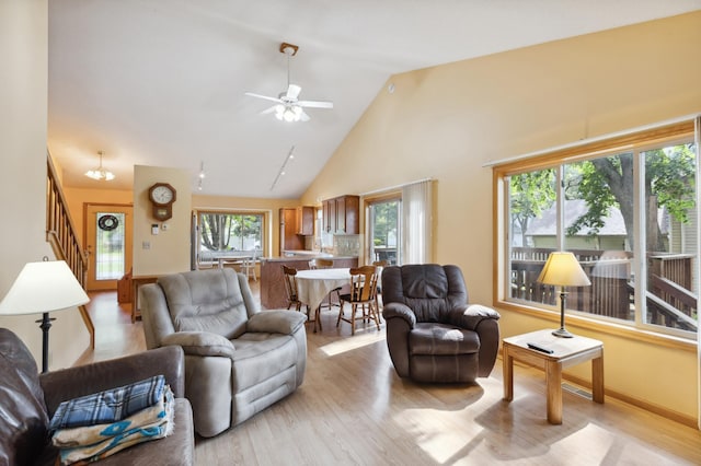 3147 94th Ln NE, Blaine, MN 55449 - living room featuring light wood-style flooring, stairs, a ceiling fan, and high vaulted ceiling
