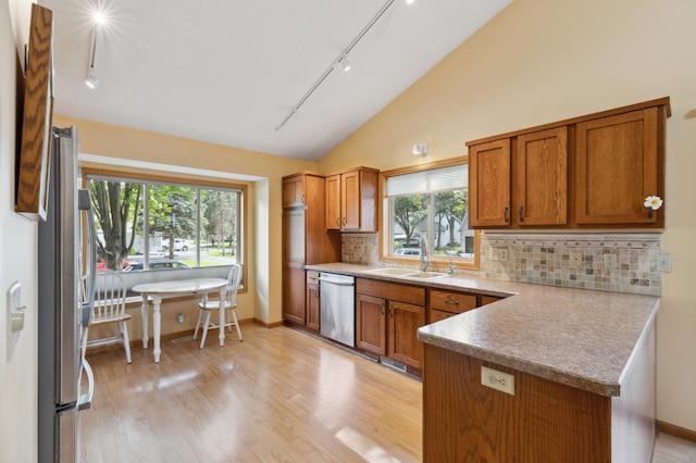 3147 94th Ln NE, Blaine, MN 55449 - kitchen featuring track lighting, stainless steel appliances, a peninsula, brown cabinets, and decorative backsplash