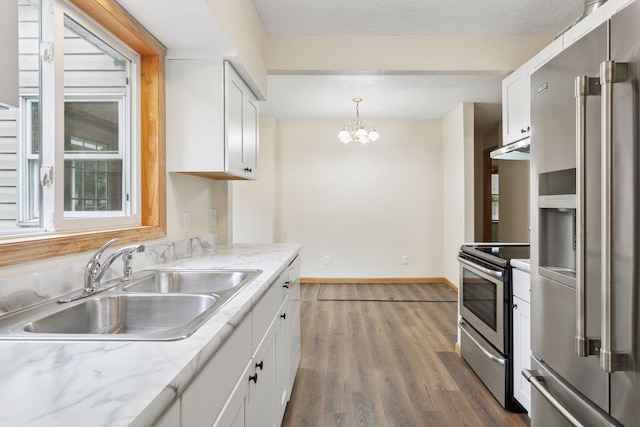 2070 Racine Ave S, Lake Saint Croix Beach, MN 55043 - kitchen featuring appliances with stainless steel finishes, white cabinets, wood finished floors, a chandelier, and under cabinet range hood