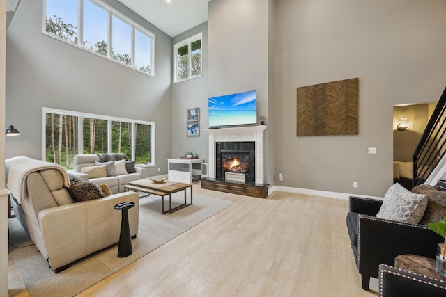 26659 145th St NW, Zimmerman, MN 55398 - living room with a high ceiling, healthy amount of natural light, light wood-style floors, a fireplace, and stairs