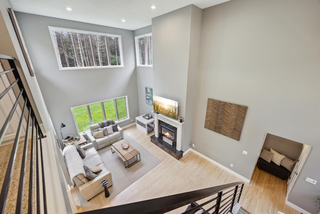 26659 145th St NW, Zimmerman, MN 55398 - living area with wood finished floors, a towering ceiling, a glass covered fireplace, and recessed lighting