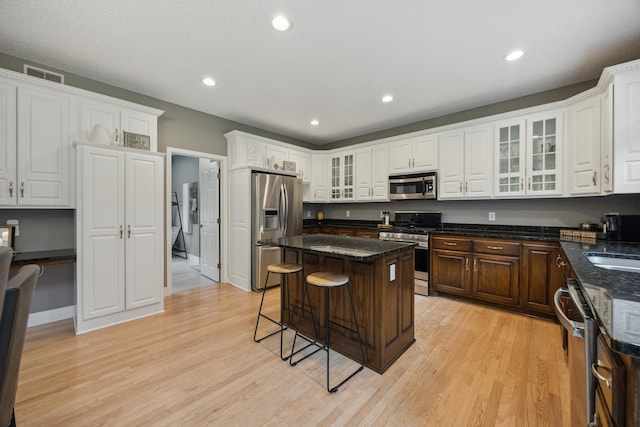 26659 145th St NW, Zimmerman, MN 55398 - kitchen with appliances with stainless steel finishes, light wood finished floors, a kitchen island, white cabinets, and recessed lighting
