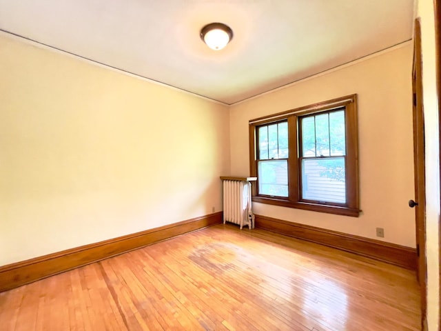 2411 Como Ave, Saint Paul, MN 55108 - empty room featuring radiator heating unit, light wood-type flooring, and crown molding