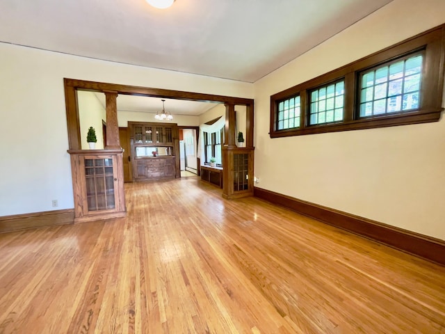 2411 Como Ave, Saint Paul, MN 55108 - unfurnished living room featuring a chandelier, light wood-type flooring, plenty of natural light, and a baseboard heating unit
