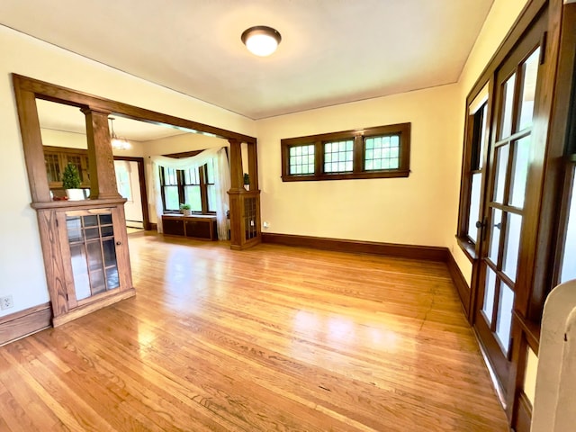 2411 Como Ave, Saint Paul, MN 55108 - spare room with light wood finished floors, ornate columns, and a baseboard radiator