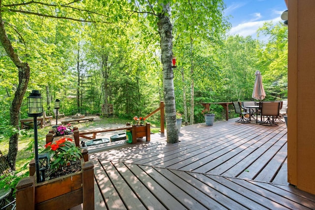 43784 Spider Lake Rd, Marcell, MN 56657 - wooden deck with outdoor dining space and a wooded view