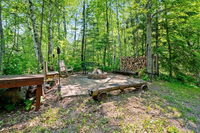 43784 Spider Lake Rd, Marcell, MN 56657 - wooden terrace featuring an outdoor fire pit and a wooded view