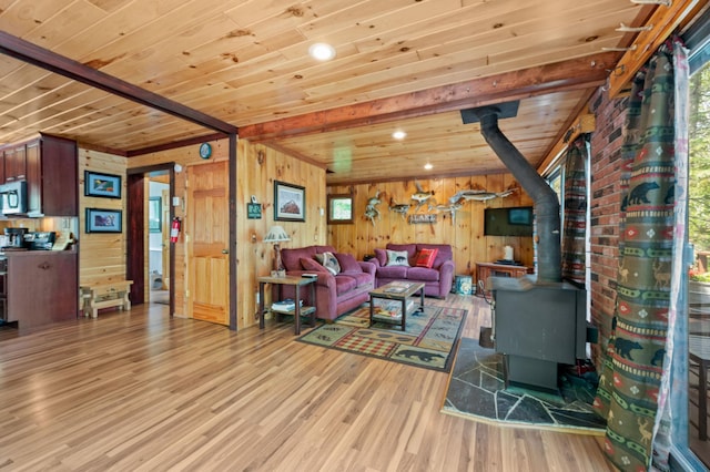 43784 Spider Lake Rd, Marcell, MN 56657 - living area with a wood stove, a wood ceiling with exposed beams, light wood-type flooring, and wood walls