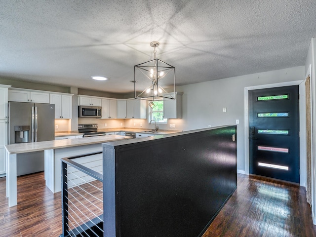 1731 Park Ave NW, Bemidji, MN 56601 - kitchen featuring appliances with stainless steel finishes, dark wood finished floors, white cabinets, light countertops, and a textured ceiling