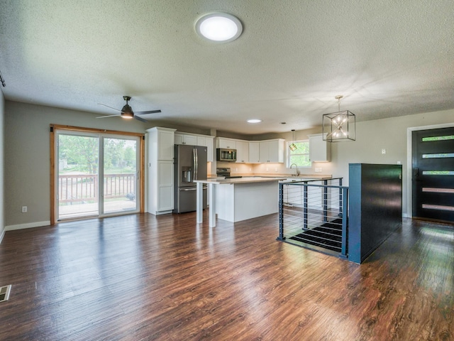 1731 Park Ave NW, Bemidji, MN 56601 - unfurnished living room featuring a textured ceiling, dark wood-style flooring, ceiling fan, and a chandelier