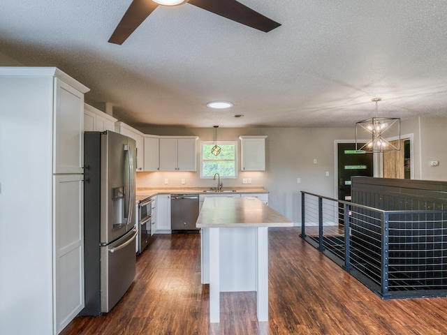 1731 Park Ave NW, Bemidji, MN 56601 - kitchen with appliances with stainless steel finishes, a textured ceiling, light countertops, white cabinetry, and dark wood-type flooring