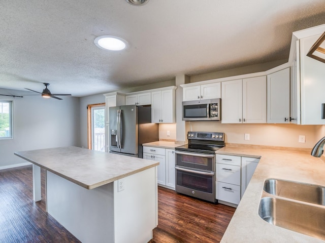1731 Park Ave NW, Bemidji, MN 56601 - kitchen featuring appliances with stainless steel finishes, white cabinets, dark wood-type flooring, ceiling fan, and a textured ceiling