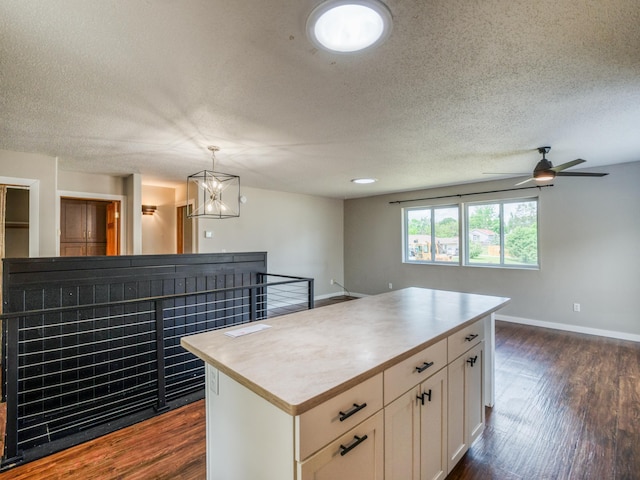 1731 Park Ave NW, Bemidji, MN 56601 - kitchen featuring dark wood-type flooring, a center island, a textured ceiling, white cabinets, and ceiling fan