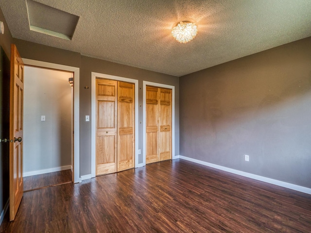 1731 Park Ave NW, Bemidji, MN 56601 - unfurnished bedroom featuring two closets, wood finished floors, and a textured ceiling