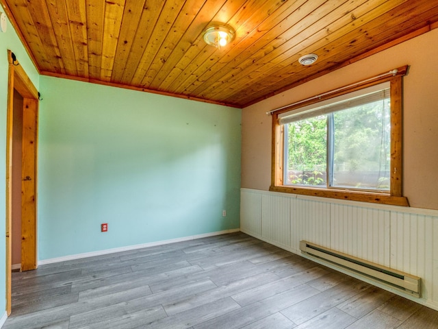 1731 Park Ave NW, Bemidji, MN 56601 - spare room featuring a baseboard heating unit, wood finished floors, wooden ceiling, ornamental molding, and wainscoting