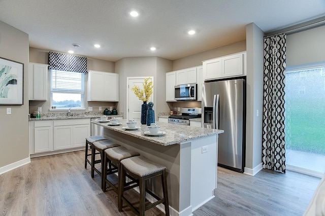 6574 208th St W, Farmington, MN 55024 - kitchen with stainless steel appliances, a kitchen island, a kitchen breakfast bar, light wood-style flooring, and recessed lighting
