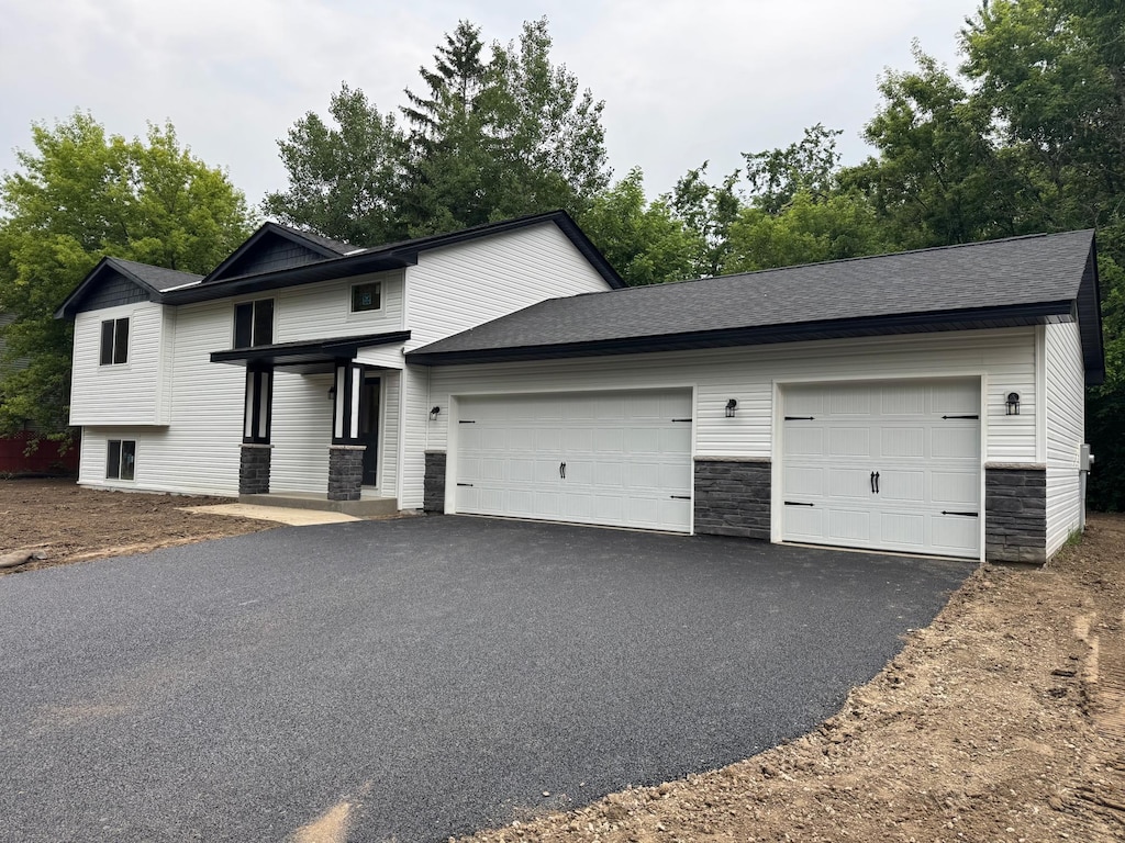 1801 Hawk Trl, Buffalo, MN 55313 - view of front of home featuring asphalt driveway, a garage, and stone siding