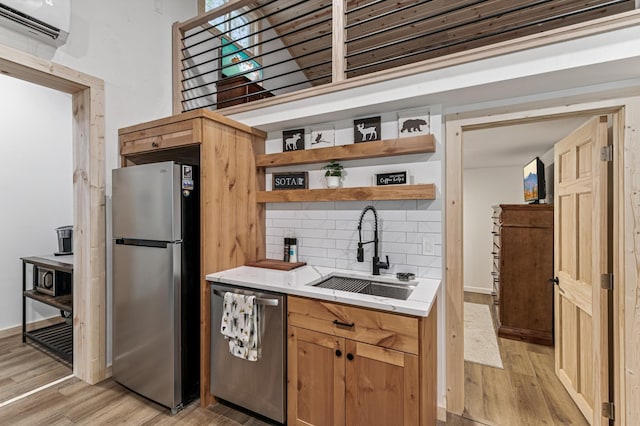 47235 184th Ave, Mcgregor, MN 55760 - kitchen with stainless steel appliances, a wall mounted AC, light wood-type flooring, tasteful backsplash, and open shelves