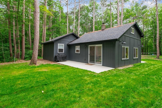 47235 184th Ave, Mcgregor, MN 55760 - rear view of property with a chimney, a shingled roof, a patio, a lawn, and board and batten siding