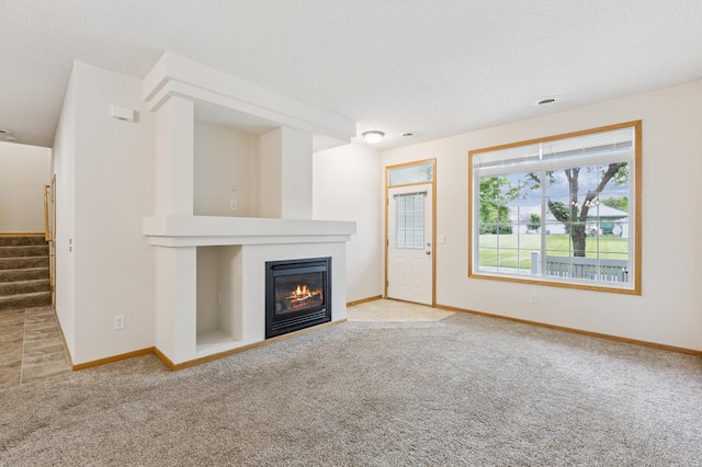 17128 Olson St NW Unit 2508, Elk River, MN 55330 - unfurnished living room featuring carpet floors, a glass covered fireplace, and stairway
