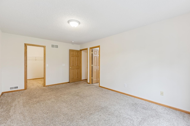 17128 Olson St NW Unit 2508, Elk River, MN 55330 - unfurnished bedroom with light carpet, a walk in closet, and a textured ceiling