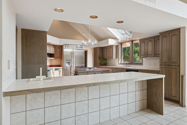 6541 Beach Rd, Eden Prairie, MN 55344 - kitchen featuring built in refrigerator, lofted ceiling, light tile patterned floors, a skylight, and a peninsula