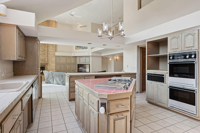6541 Beach Rd, Eden Prairie, MN 55344 - kitchen with double oven, light tile patterned floors, tile counters, a kitchen island, and a high ceiling