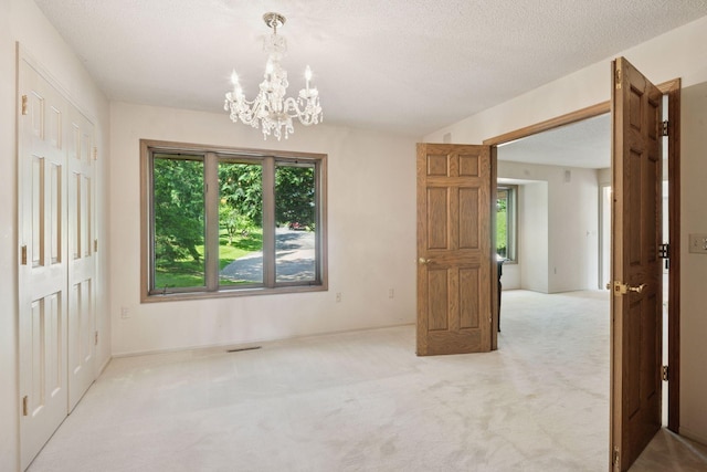 6541 Beach Rd, Eden Prairie, MN 55344 - carpeted spare room featuring a chandelier and a textured ceiling