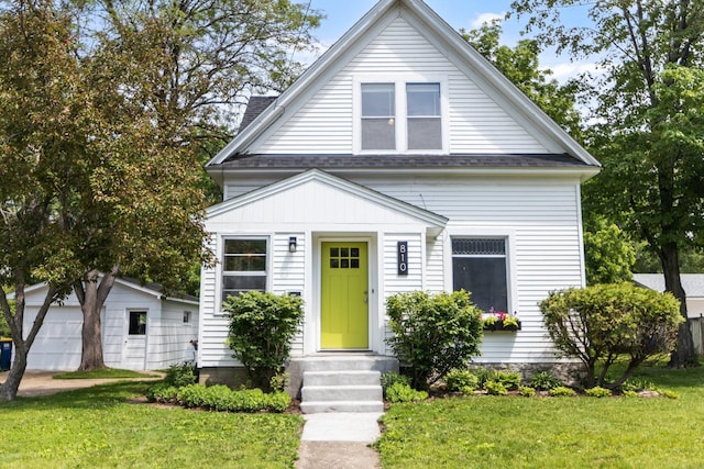 810 7th St NW, Faribault, MN 55021 - view of front facade with entry steps, an outbuilding, a front yard, and a shingled roof