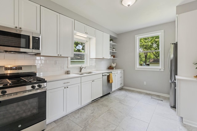 810 7th St NW, Faribault, MN 55021 - kitchen with appliances with stainless steel finishes, tasteful backsplash, light countertops, white cabinetry, and open shelves