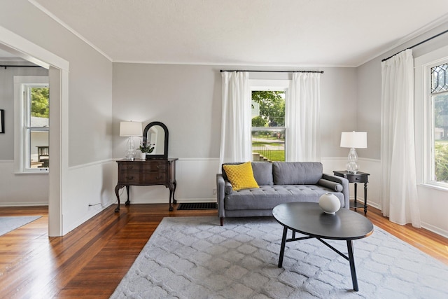 810 7th St NW, Faribault, MN 55021 - living room with wood finished floors, ornamental molding, and a wainscoted wall