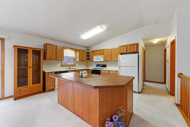 4929 Valley Dr NW, Rochester, MN 55901 - kitchen featuring white appliances, vaulted ceiling, light colored carpet, and brown cabinetry