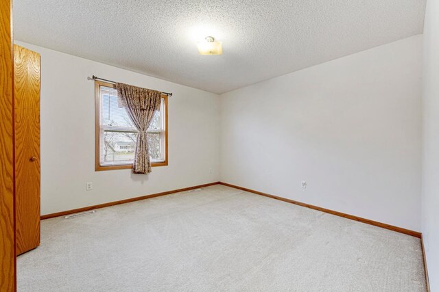 4929 Valley Dr NW, Rochester, MN 55901 - spare room featuring carpet flooring and a textured ceiling