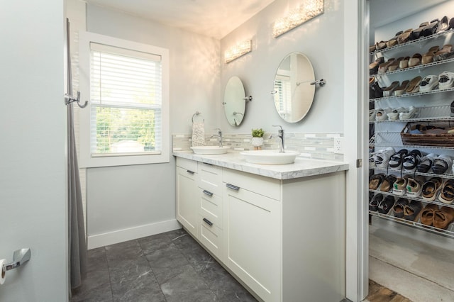 202 Park St, Alexandria, MN 56308 - bathroom featuring double vanity, backsplash, and a spacious closet