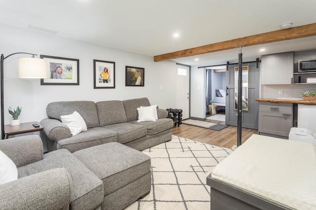 202 Park St, Alexandria, MN 56308 - living room featuring recessed lighting, a barn door, beamed ceiling, and light wood-style flooring