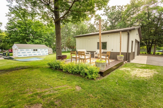 202 Park St, Alexandria, MN 56308 - view of green lawn featuring an outdoor structure, a deck, an outdoor living space, view of scattered trees, and a garage