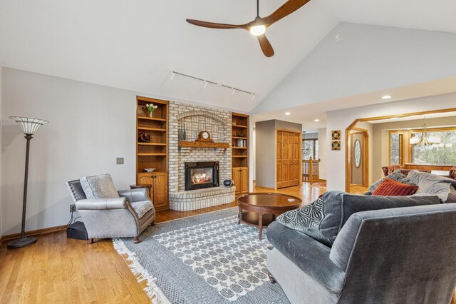 8011 County Road 13 SE, Delano, MN 55328 - living area with ceiling fan, light wood-type flooring, lofted ceiling, track lighting, and a brick fireplace