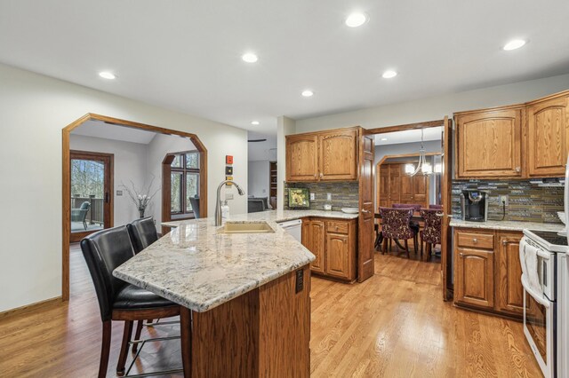 8011 County Road 13 SE, Delano, MN 55328 - kitchen with a kitchen breakfast bar, white appliances, light wood finished floors, decorative backsplash, and recessed lighting