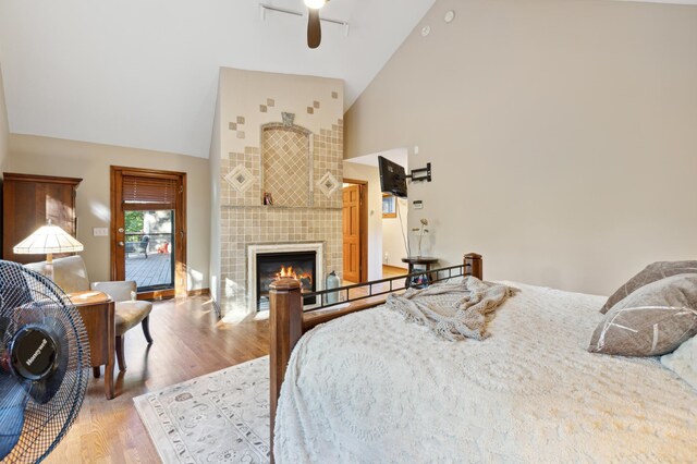 8011 County Road 13 SE, Delano, MN 55328 - bedroom featuring high vaulted ceiling, wood finished floors, a tiled fireplace, and ceiling fan