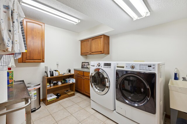 8011 County Road 13 SE, Delano, MN 55328 - washroom with washing machine and clothes dryer, cabinet space, light tile patterned floors, and a textured ceiling