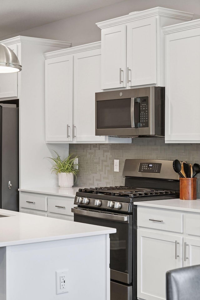 3841 Hyde Ave N, Oakdale, MN 55128 - kitchen featuring appliances with stainless steel finishes, white cabinetry, light countertops, and backsplash