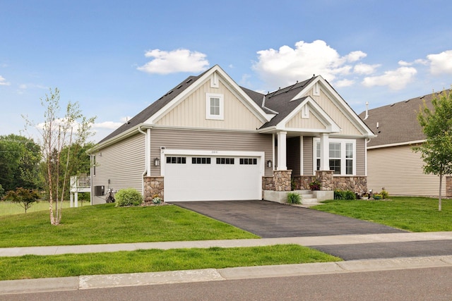 3841 Hyde Ave N, Oakdale, MN 55128 - craftsman-style home featuring board and batten siding, asphalt driveway, stone siding, and a front lawn