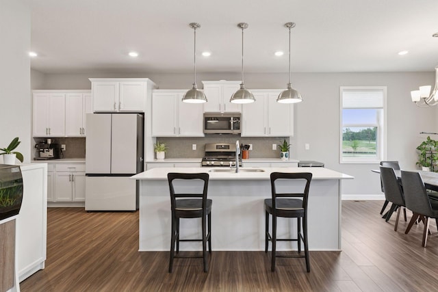 3841 Hyde Ave N, Oakdale, MN 55128 - kitchen featuring appliances with stainless steel finishes, dark wood-type flooring, a center island with sink, light countertops, and recessed lighting