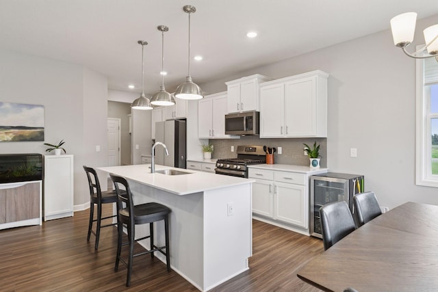 3841 Hyde Ave N, Oakdale, MN 55128 - kitchen featuring stainless steel appliances, wine cooler, a center island with sink, backsplash, and dark wood finished floors