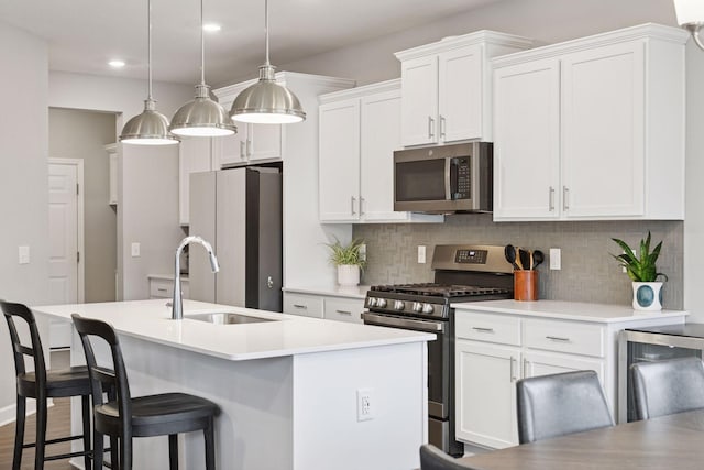 3841 Hyde Ave N, Oakdale, MN 55128 - kitchen with appliances with stainless steel finishes, backsplash, a kitchen island with sink, white cabinets, and recessed lighting